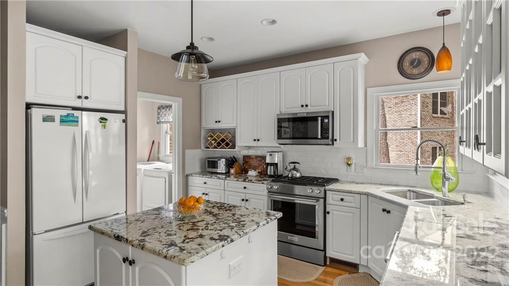 11147 Scullers Run Tega Cay, SC 29708 - Photo 21 of 39 a kitchen with stainless steel appliances granite countertop a stove top oven a refrigerator a sink and dishwasher with white cabinets