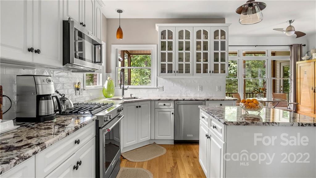 11147 Scullers Run Tega Cay, SC 29708 - Photo 23 of 39 a kitchen with stainless steel appliances granite countertop a stove a sink and a granite counter tops with white cabinets