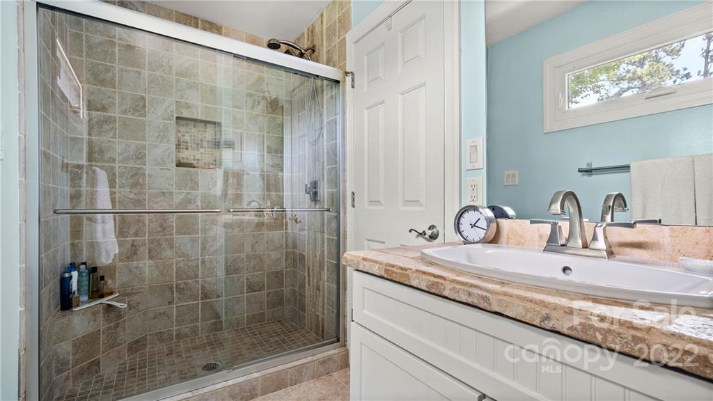 11147 Scullers Run Tega Cay, SC 29708 - Photo 31 of 39 a bathroom with a granite countertop sink a mirror and a shower