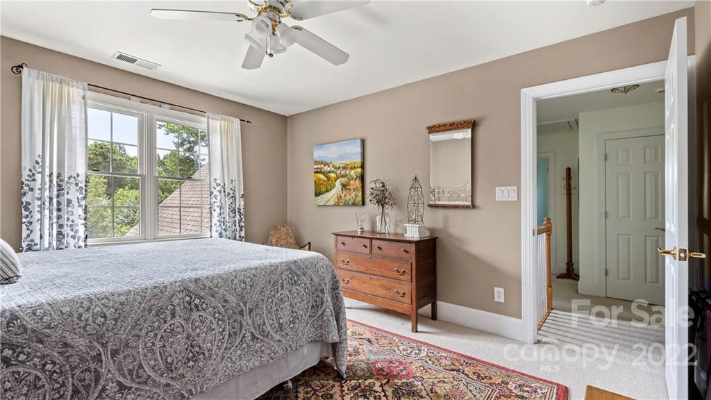 11147 Scullers Run Tega Cay, SC 29708 - Photo 35 of 39 a bedroom with a bed and a chandelier