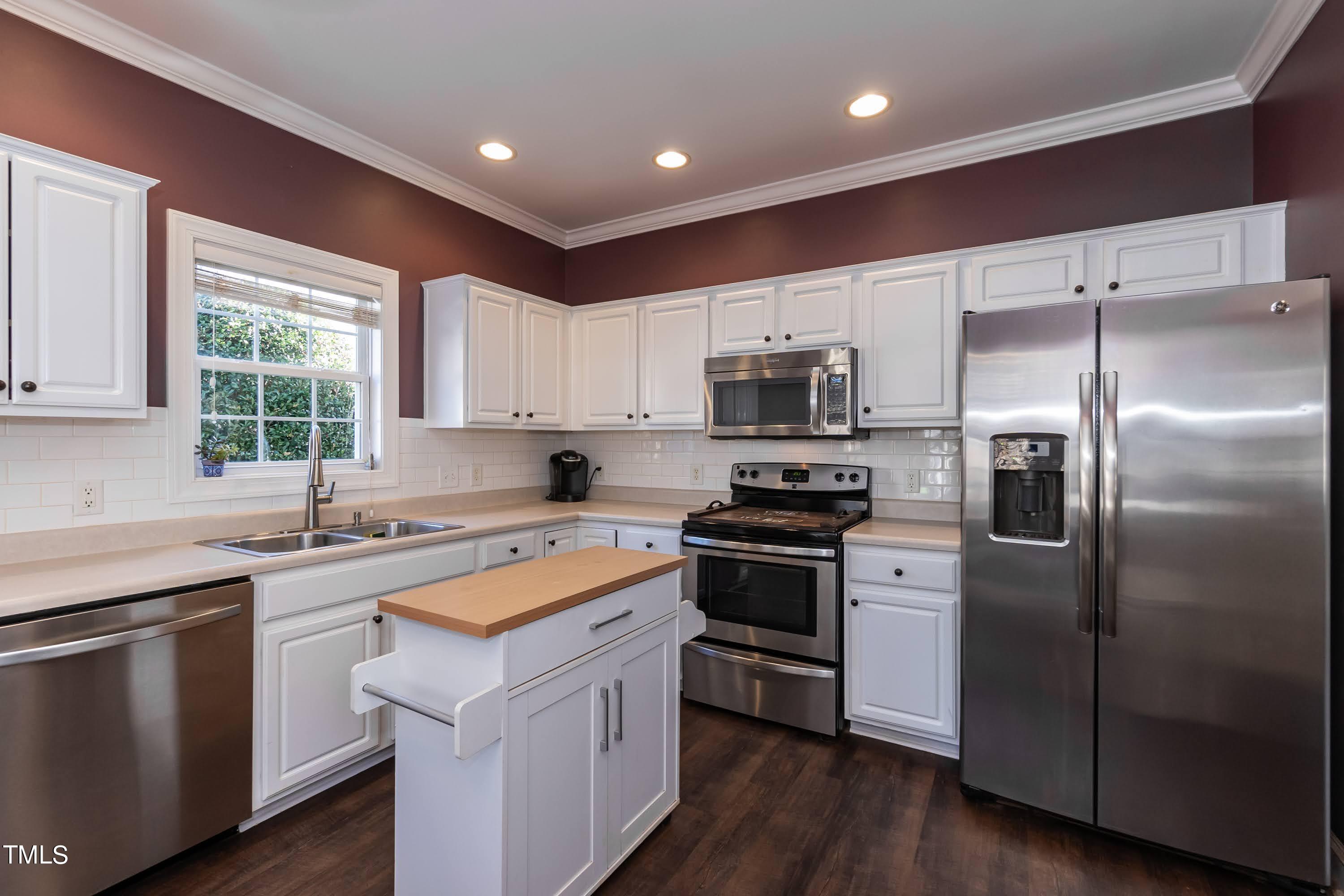 5001 Morning Edge Drive Raleigh, NC 27613 - Photo 7 of 25 a kitchen with a sink appliances a window and a counter top space
