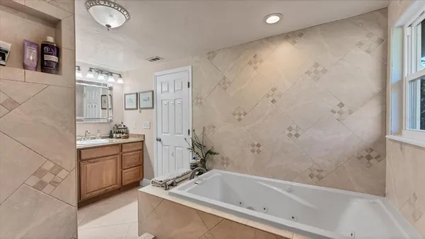 a bathroom with a tub sink and mirror
