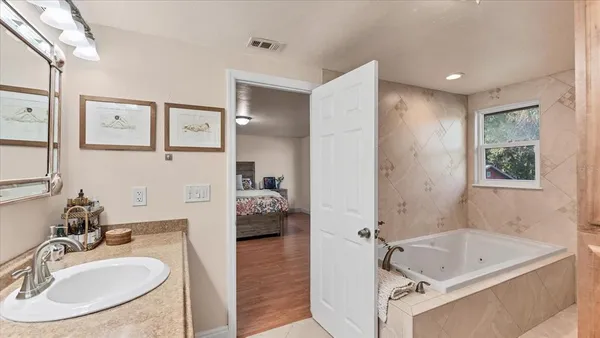 a bathroom with a tub sink and mirror