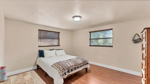 a bedroom with a bed and wooden floor