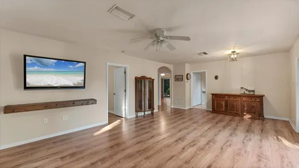 a view of a room with wooden floor and ceiling fan