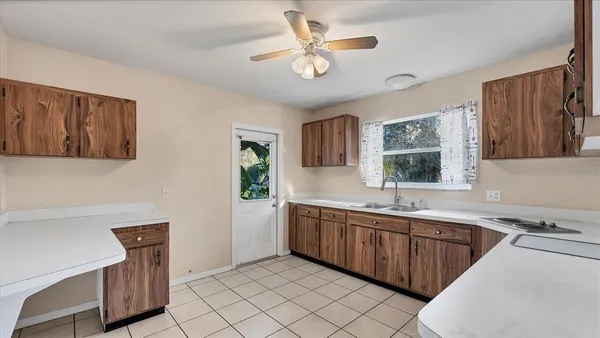 a view of kitchen with sink refrigerator and window
