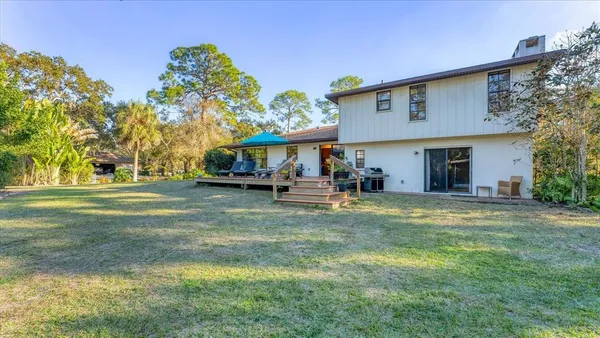 a view of house with garden and tall trees