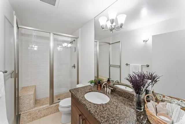 a bathroom with a granite countertop sink a toilet and a mirror