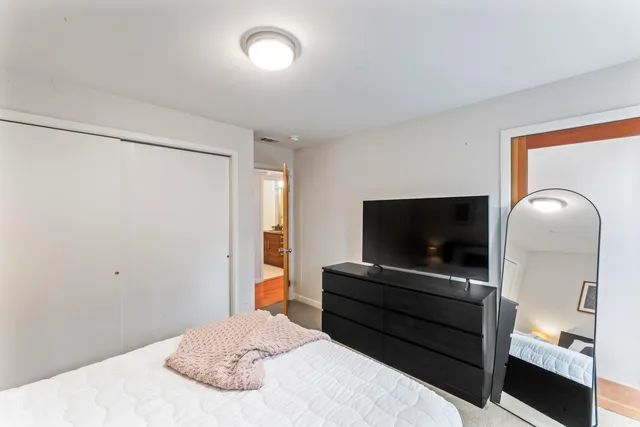 a bedroom with a bed and a flat screen tv