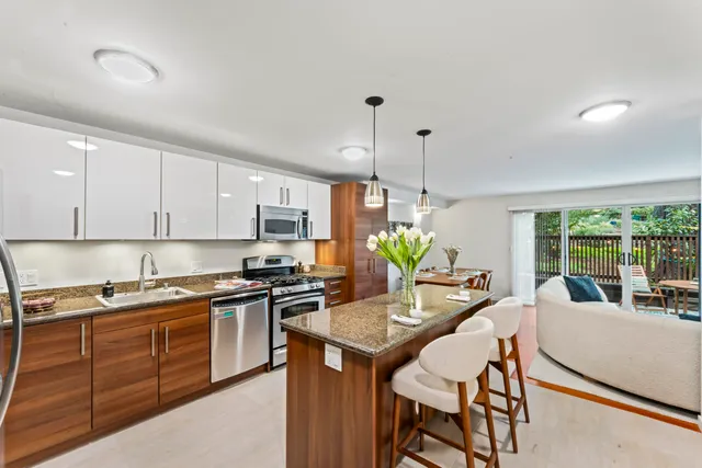 a kitchen with a stove a sink a dining table and chairs