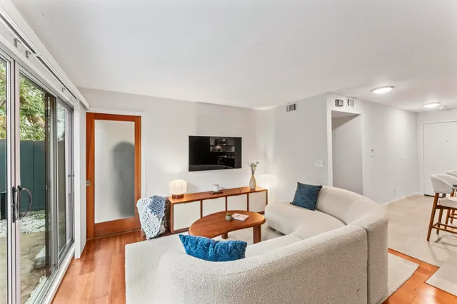 a living room with furniture a flat screen tv and a large window
