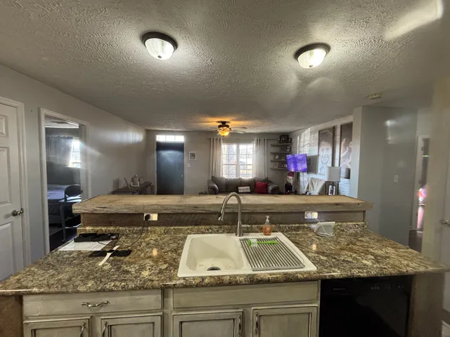 a kitchen with stainless steel appliances granite countertop a refrigerator stove and sink