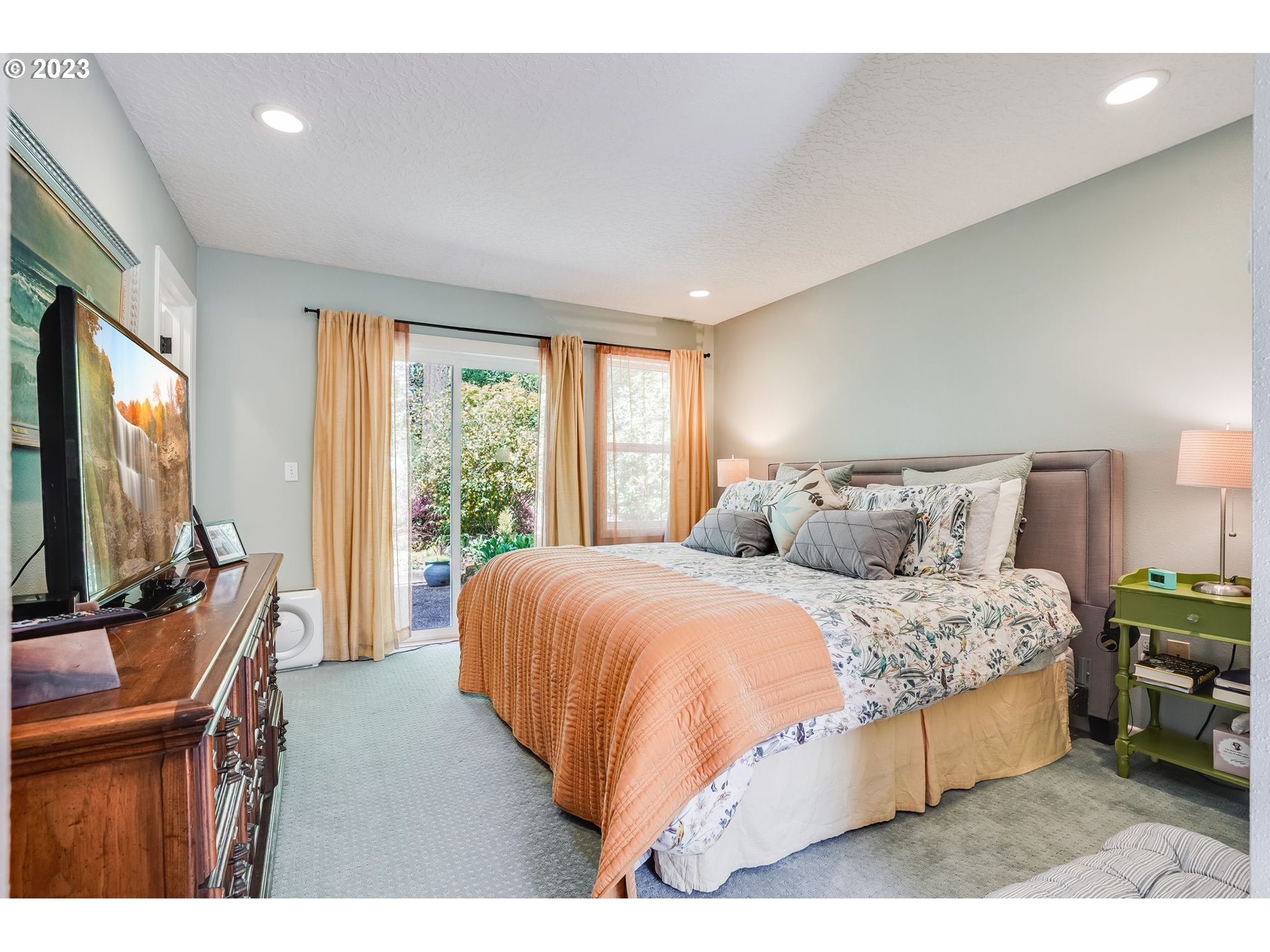 644 South Palatine Hill Road Portland, OR 97219 - Photo 18 of 46 a bedroom with a large bed and a flat tv screen on dresser