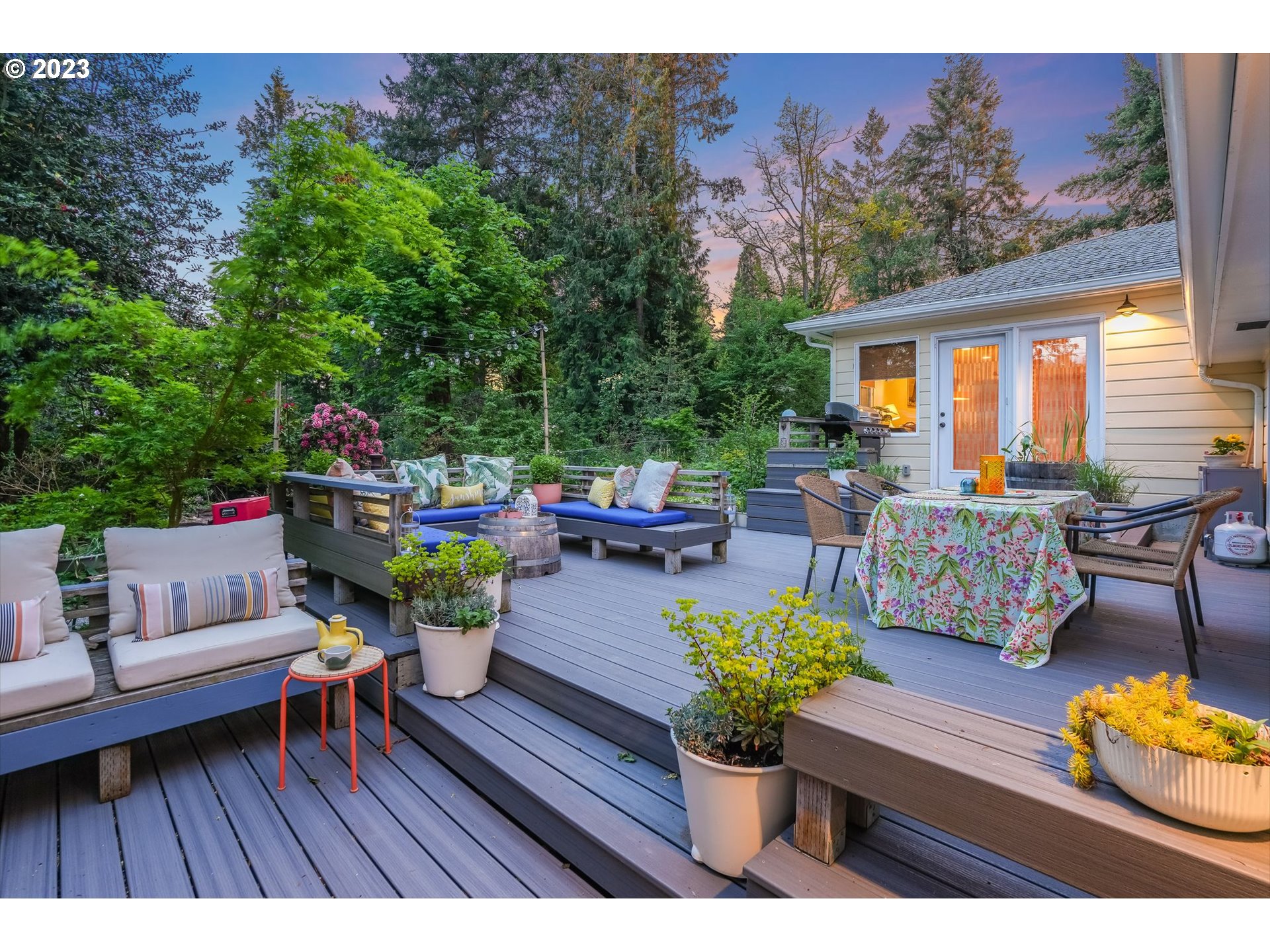 644 South Palatine Hill Road Portland, OR 97219 - Photo 25 of 46 a view of a patio with couches table and chairs potted plants and a large tree