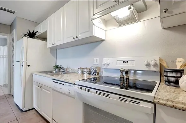 a kitchen with appliances cabinets and a table