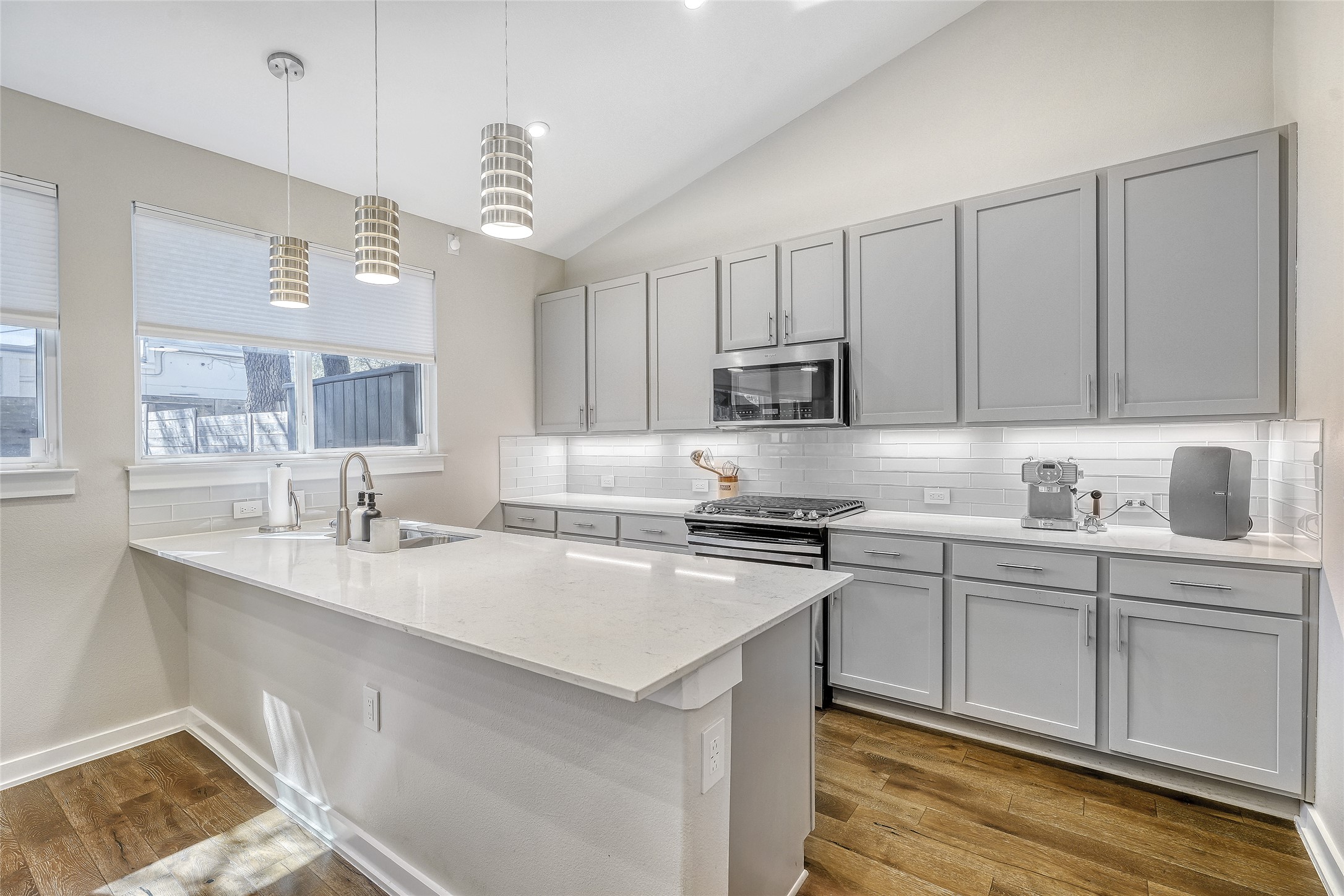 6800 Menchaca Road, Unit 5 Austin, TX 78745 - Photo 14 of 28 a kitchen with kitchen island granite countertop a sink white cabinets and stainless steel appliances