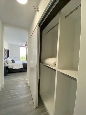 a view of a bedroom with a bed and a window