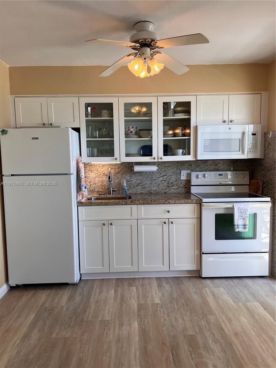 2600 North Surf Road, Unit 403 Hollywood, FL 33019 - Photo 10 of 24 a kitchen with granite countertop white cabinets and white appliances