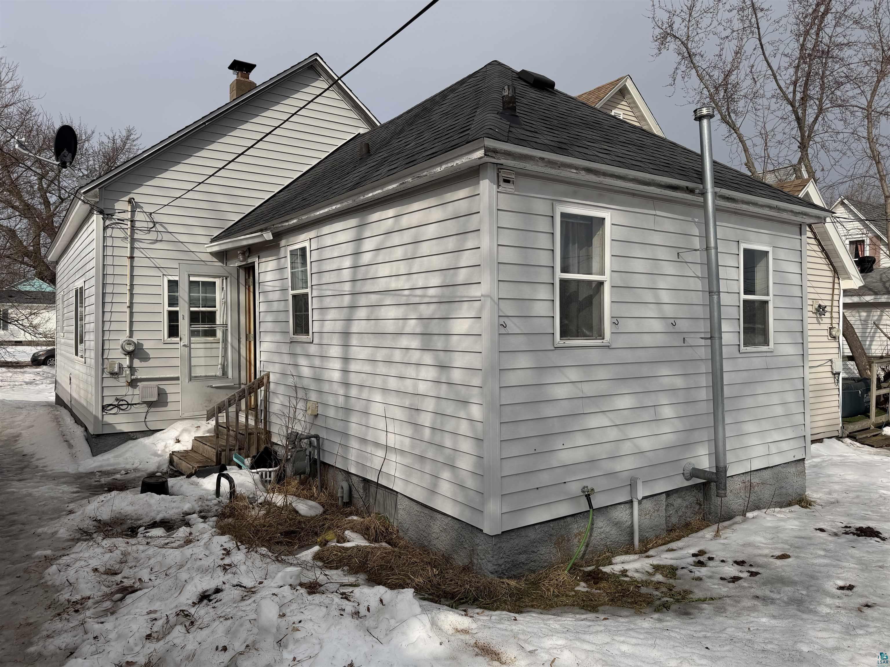 1720 Iowa Avenue Superior, WI 54880 - Photo 2 of 11 View of side of property with roof with shingles and a chimney