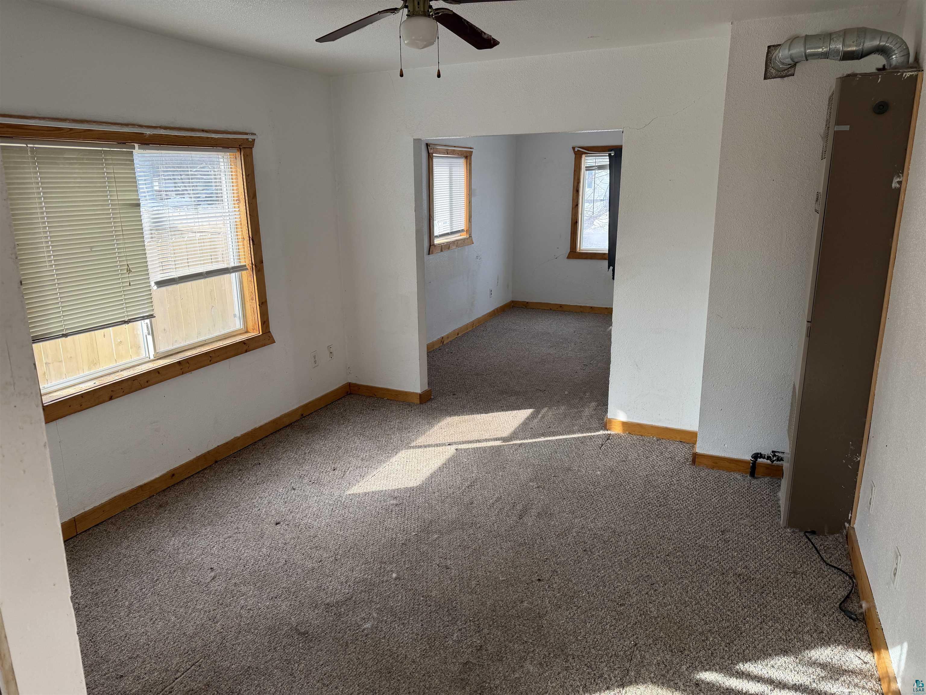 1720 Iowa Avenue Superior, WI 54880 - Photo 3 of 11 Spare room with a heating unit, carpet flooring, and a ceiling fan
