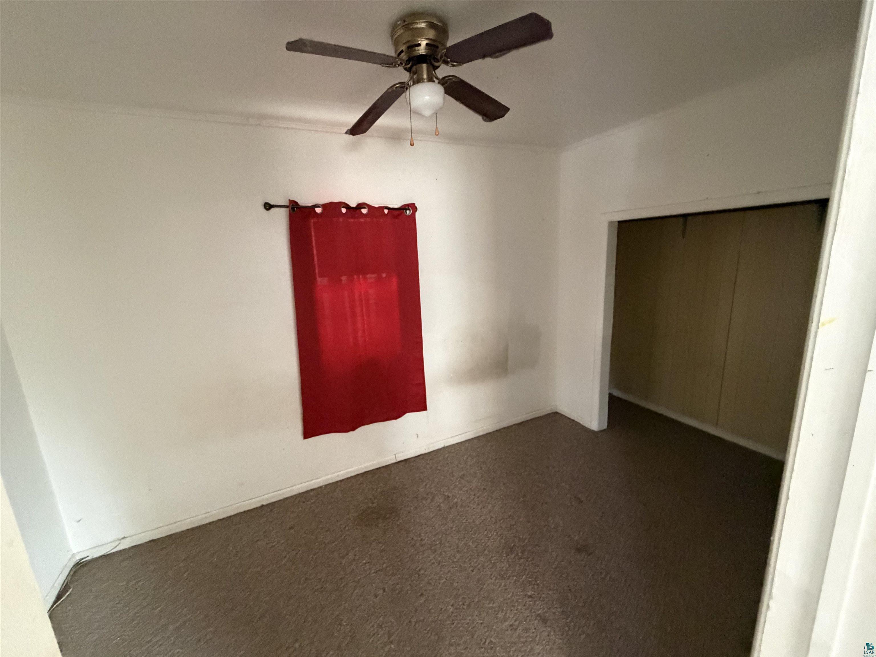 1720 Iowa Avenue Superior, WI 54880 - Photo 7 of 11 Unfurnished bedroom featuring a closet, ceiling fan, and dark colored carpet