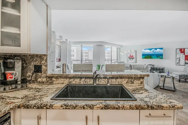a kitchen with kitchen island granite countertop a sink and a counter top space