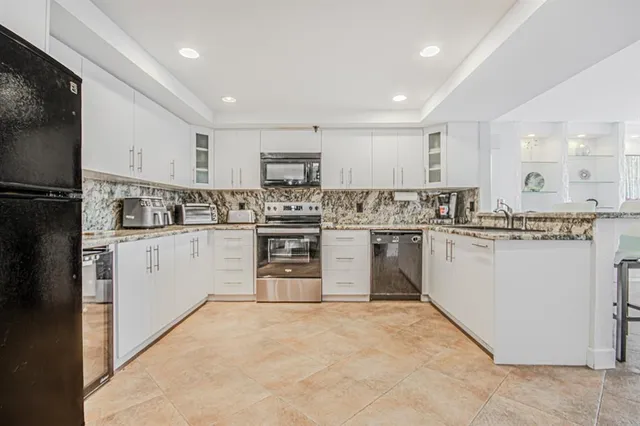 a kitchen with white cabinets stainless steel appliances and sink