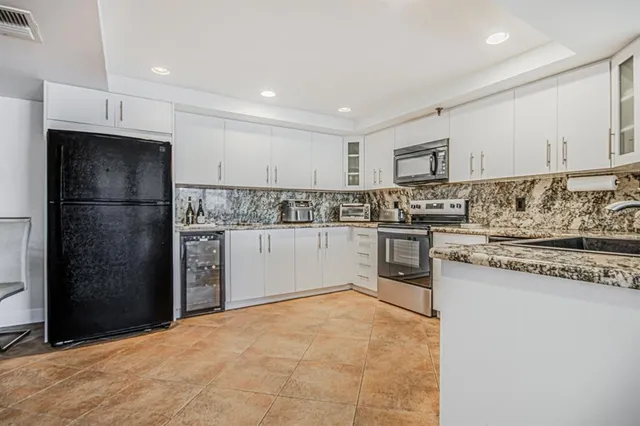 a kitchen with stainless steel appliances granite countertop a refrigerator and a stove top oven