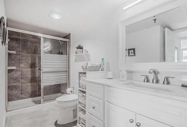 a bathroom with a sink a toilet and shower