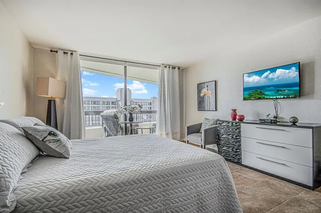 a bedroom with a large bed and a flat tv screen on dresser