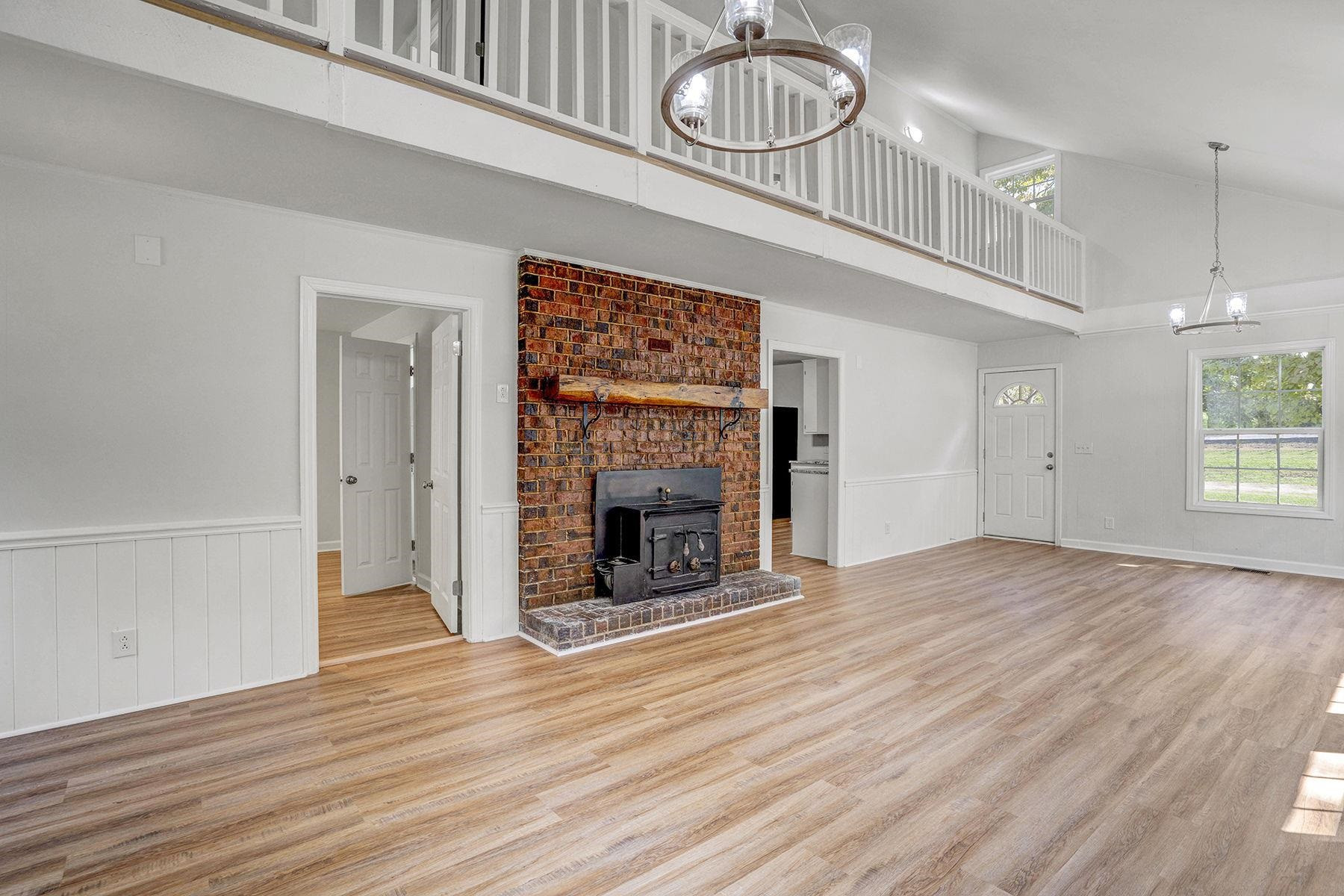 170 Temple Road Bunnlevel, NC 28323 - Photo 6 of 34 an empty room with wooden floor fireplace and windows