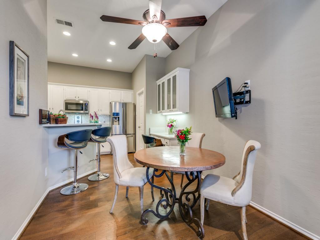 10805 Stone Canyon Road Dallas, TX 75230 - Photo 17 of 19 a kitchen with stainless steel appliances kitchen island granite countertop a dining table chairs and a refrigerator