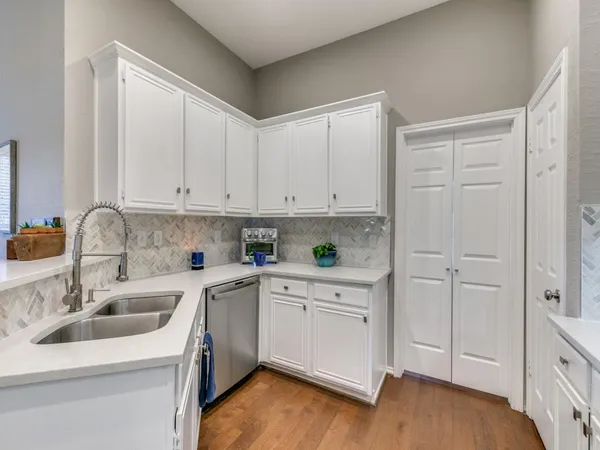 a kitchen with a sink cabinets and wooden floor