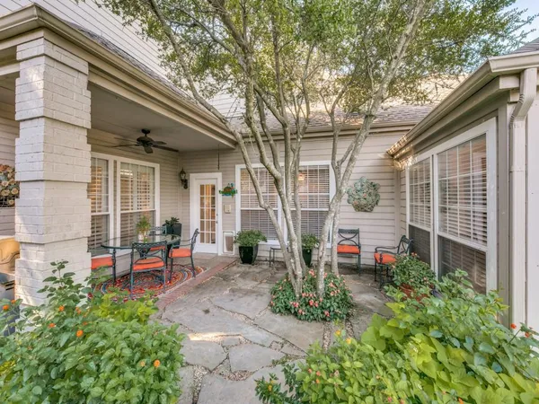 a view of a chair and table in backyard of the house