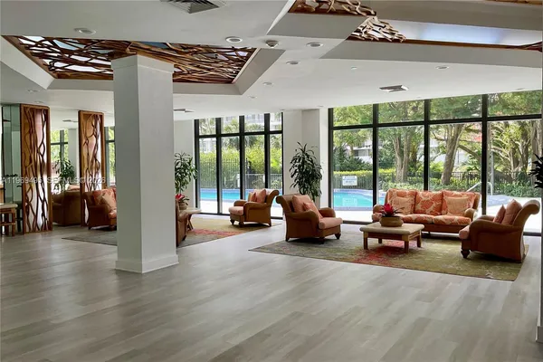 a view of a hallway with two couches and a flat screen tv