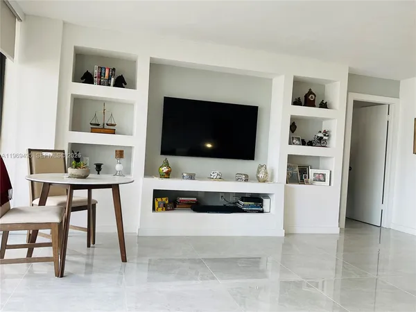 a living room with furniture and a dining table with kitchen view