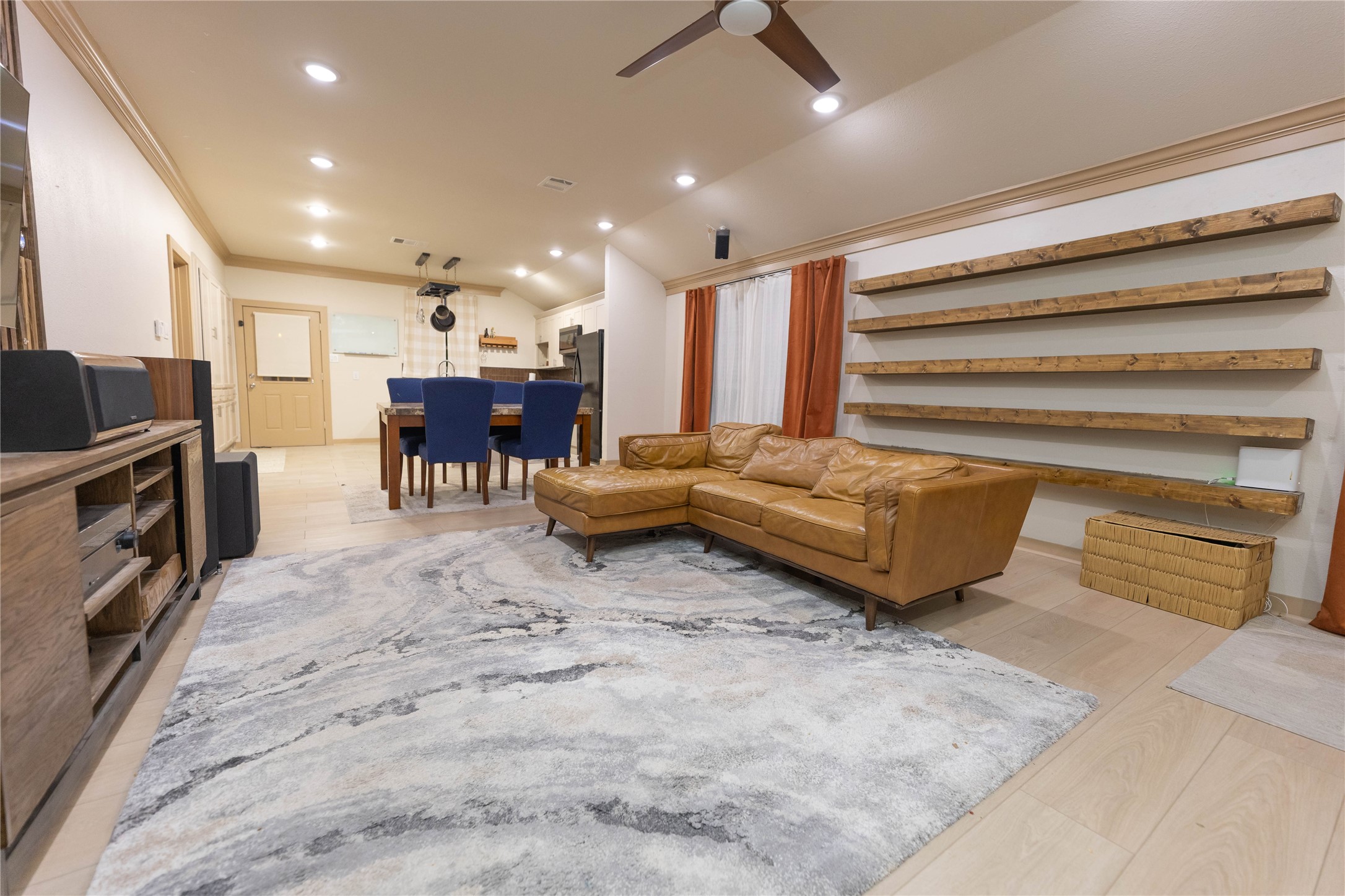 8007 Capitol Street Houston, TX 77012 - Photo 6 of 25 This spacious living area features a modern open concept with recessed lighting, and expansive wooden shelves for decor. Adjacent is a dining area, leading to a well-equipped kitchen. The room is bright and inviting, perfect for entertaining.