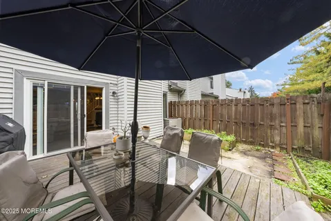 a view of a patio with table and chairs under an umbrella
