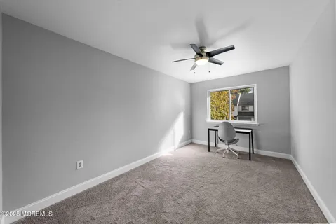 a view of a workspace with furniture and a window