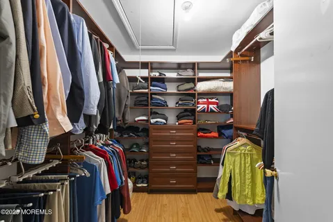 a view of walk in closet with clothes and shoes