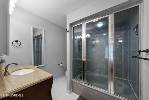 a bathroom with a granite countertop sink toilet and shower