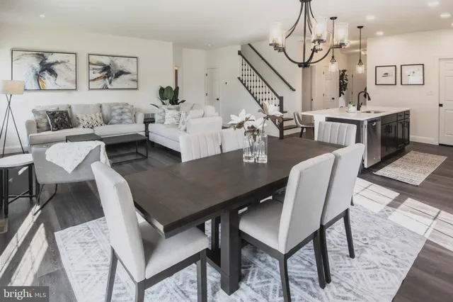 a view of a dining room with furniture a chandelier and wooden floor