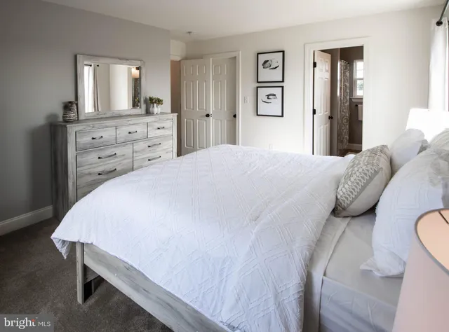 a bedroom with white cabinets and wooden floor