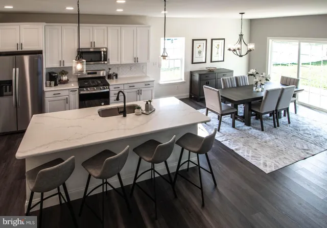 a living room with furniture a wooden floor and a kitchen view