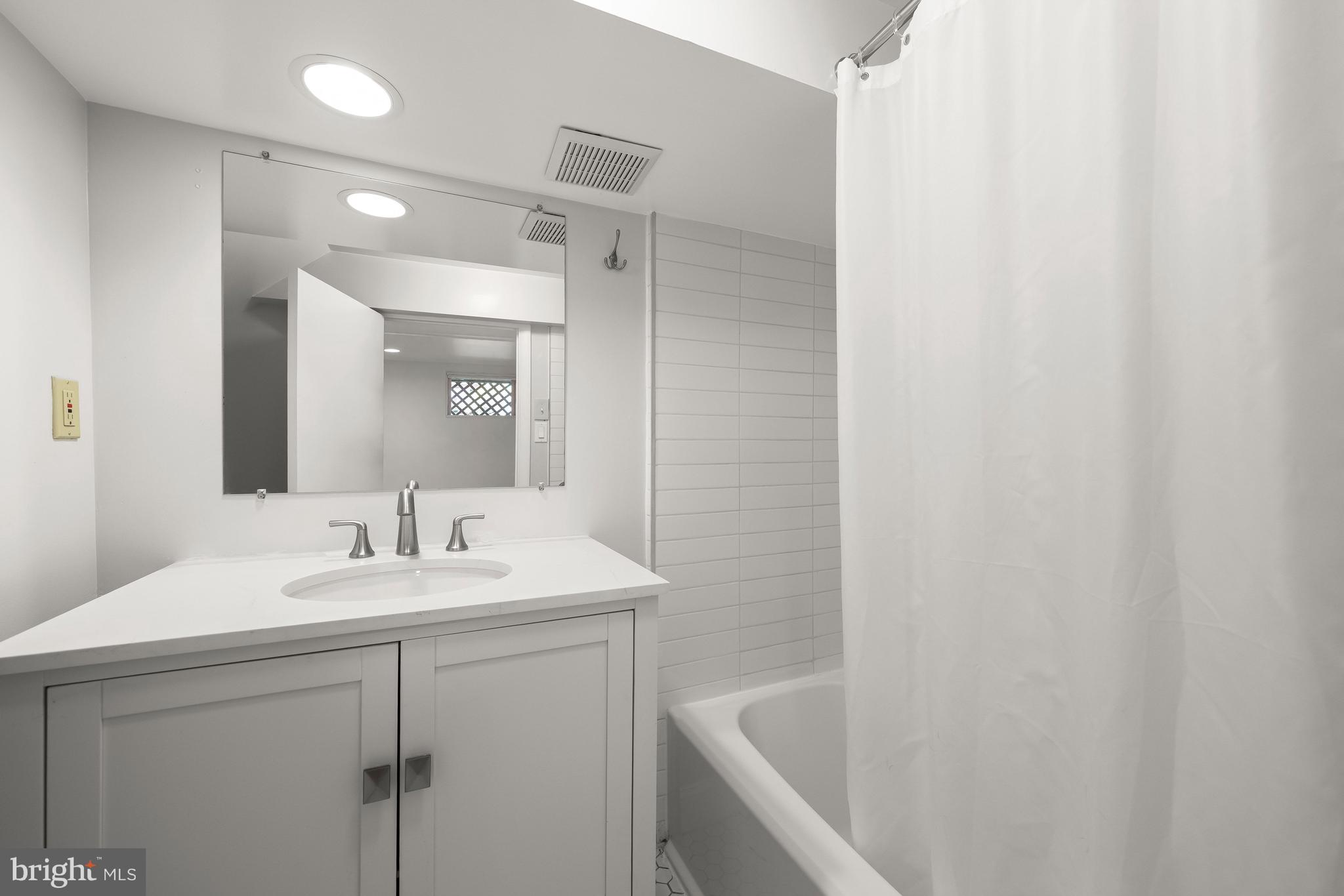 8800 Maywood Avenue Silver Spring, MD 20910 - Photo 31 of 41 a bathroom with a sink a mirror and a bathtub