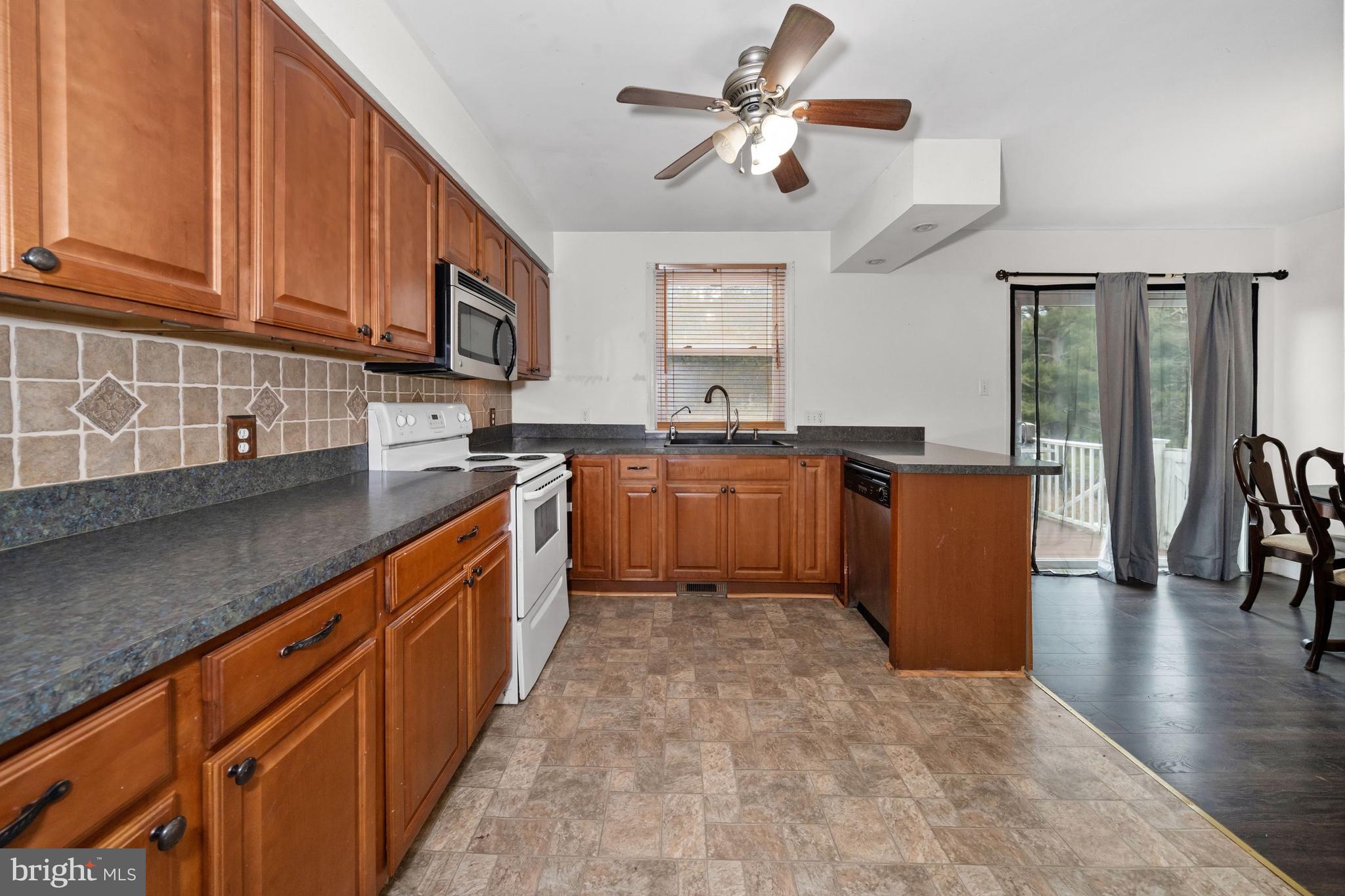 1023 Old Telegraph Road Warwick, MD 21912 - Photo 2 of 20 a kitchen with stainless steel appliances granite countertop a sink dishwasher stove top oven and cabinets with wooden floor