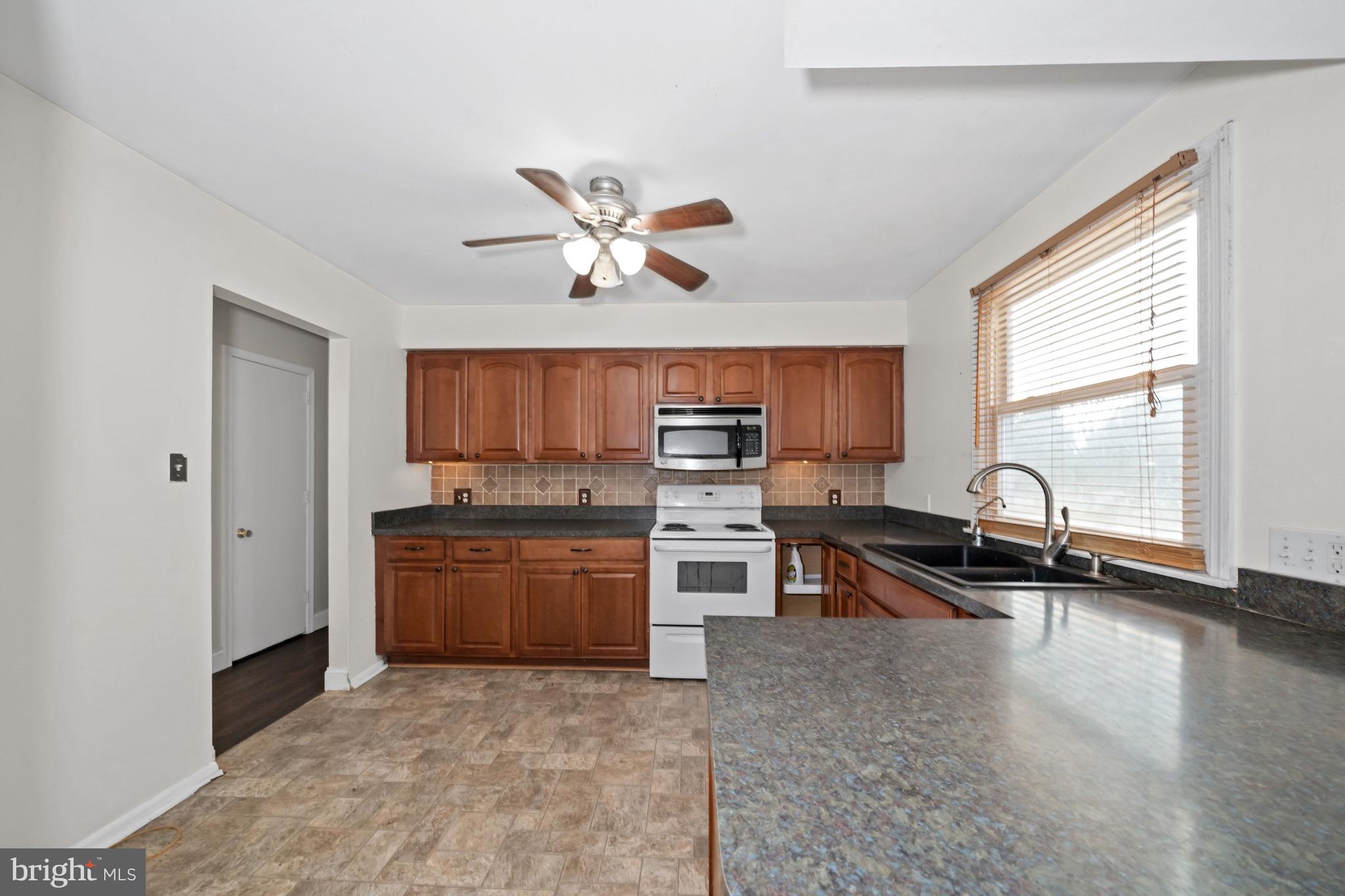 1023 Old Telegraph Road Warwick, MD 21912 - Photo 3 of 20 a open kitchen with stainless steel appliances granite countertop a stove top oven a sink a dining table and chairs with wooden floor