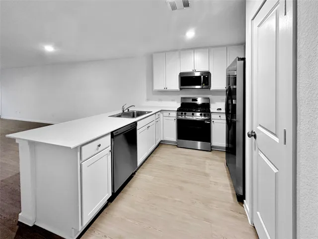 a kitchen with stainless steel appliances granite countertop a stove a refrigerator and a sink