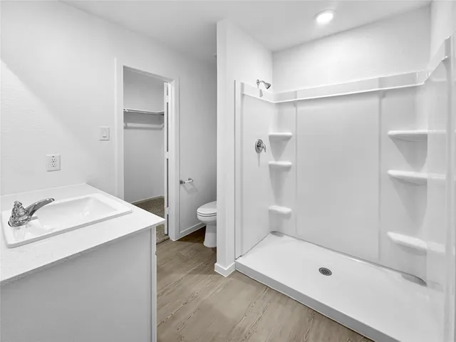 a bathroom with a tub sink toilet and shower