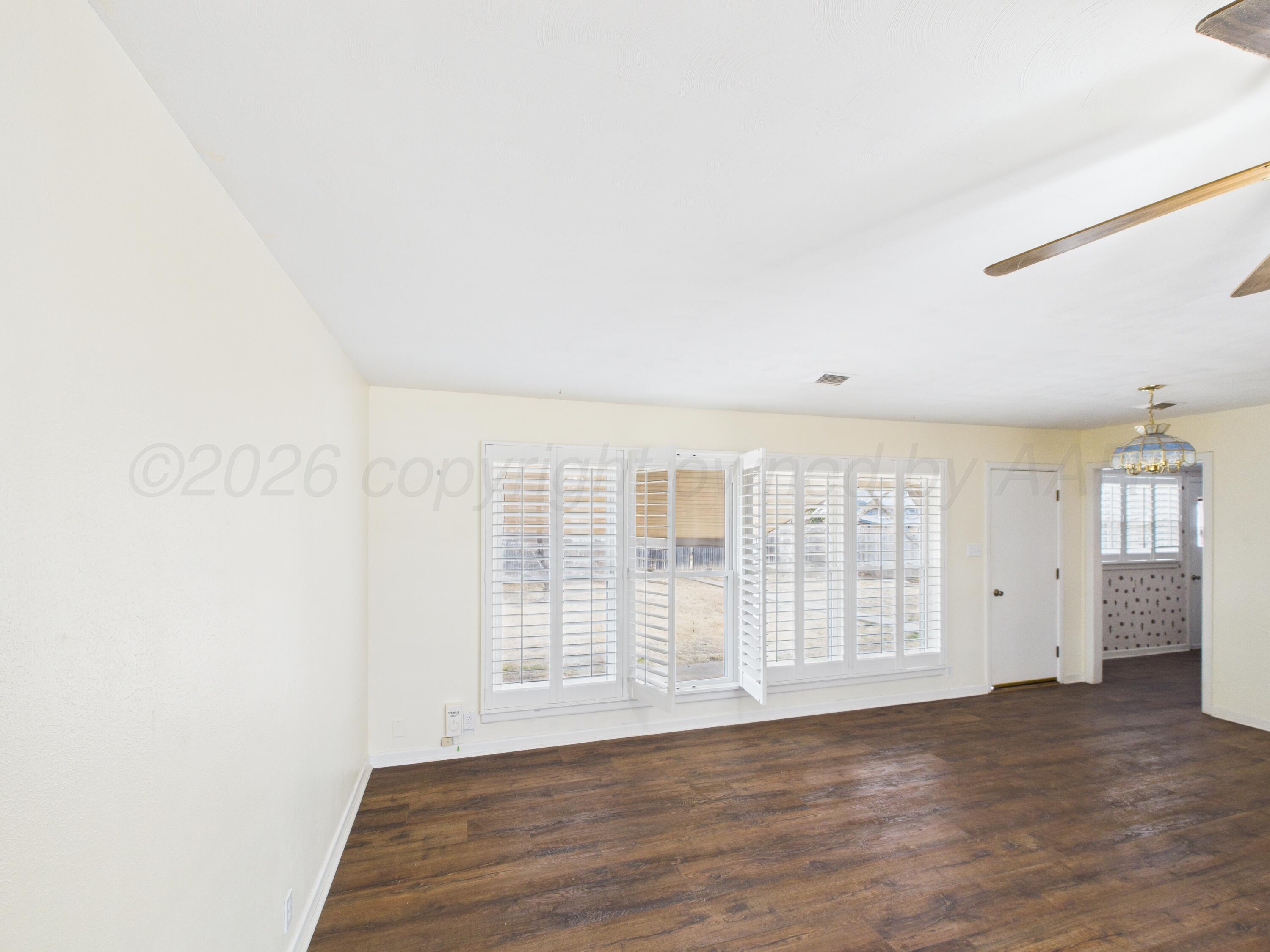 528 North Red Deer Street Pampa, TX 79065 - Photo 11 of 41 an empty room with wooden floor and windows